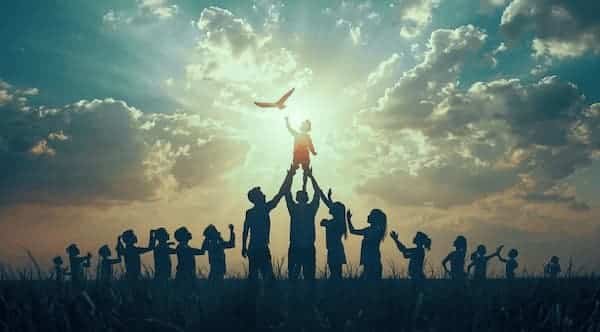 Silhouetted figures celebrating a child.